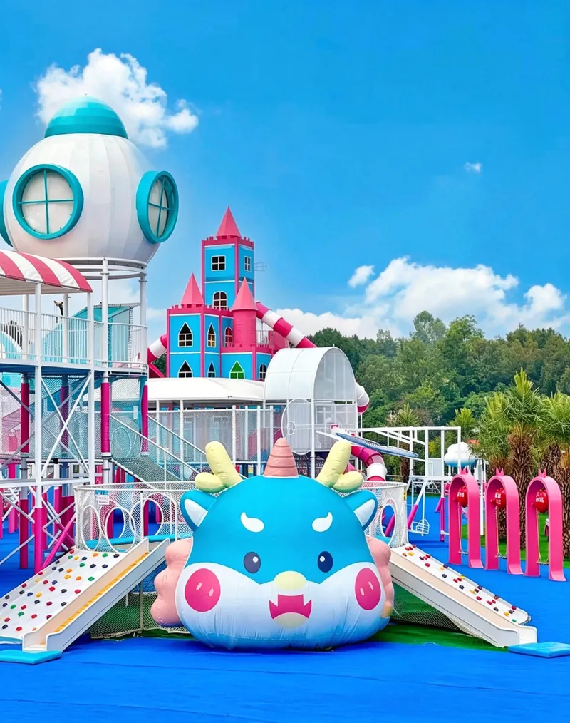 The little blue dragon — A little blue dragon lies on the grass, and children slide down its back.